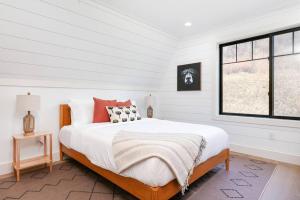a white bedroom with a large bed and a window at Mtn Views + Fire Pit + Secluded in Westfield