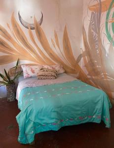 um quarto com uma cama com uma grande pintura na parede em Casa Amadis em Querétaro