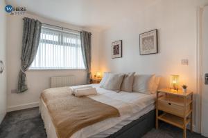 a bedroom with a large bed and a window at Gorgeous 2 bed apartment Durham 
