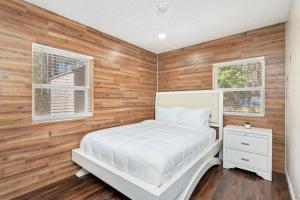 een slaapkamer met een wit bed en 2 ramen bij Westville Pines Cabin 
