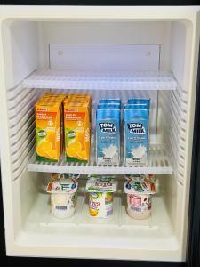 a refrigerator filled with yogurt and other food items at Nouadhibou Guest House in Nouadhibou