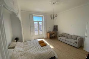 a white bedroom with a bed and a couch at Sunny luxury flat in the city centre in Montpellier