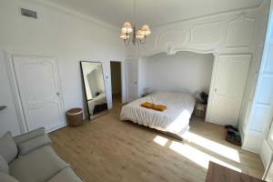 a white bedroom with a bed and a mirror at Sunny luxury flat in the city centre in Montpellier