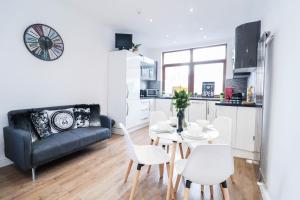 a living room with a couch and a table and chairs at Stunning Split Level Apartment in London