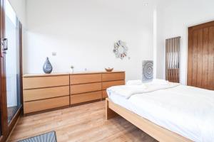 a bedroom with a large bed and a wooden dresser at Stunning Split Level Apartment in London