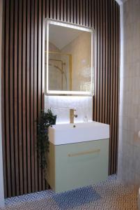 ein Bad mit einem Waschbecken und einem Spiegel in der Unterkunft Cosy Renovated House in Warrington in Warrington