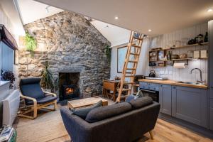 a kitchen and living room with a stone fireplace at Jura, Mrs Leonard's Cottage in Isle of Jura