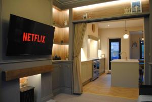 a kitchen with a tv on a wall at Cosy Renovated House in Warrington in Warrington