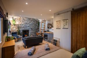 a room with a bed and a stone fireplace at Jura, Mrs Leonard's Cottage in Isle of Jura