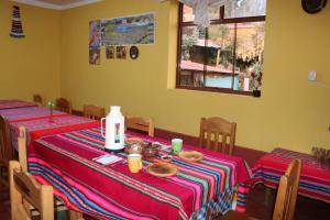 un comedor con dos mesas con comida. en LOVELAND AMANTANI LODGE - Un lugar encantado en Ocosuyo