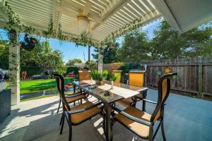 a patio with a table and chairs under a pergola at Safari Adventure: Arcade, Golf, Playground, Cars & More! in Garden Grove