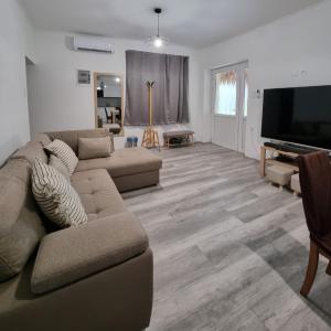 a living room with a couch and a flat screen tv at Somló Kiss Birtok in Somlószőlős