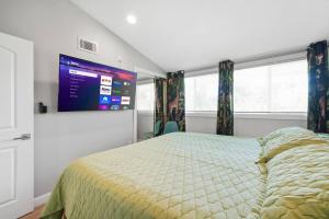a bedroom with a bed and a tv on the wall at Safari Adventure: Arcade, Golf, Playground, Cars & More! in Garden Grove