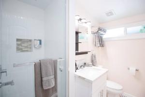 a white bathroom with a sink and a toilet at Safari Adventure: Arcade, Golf, Playground, Cars & More! in Garden Grove