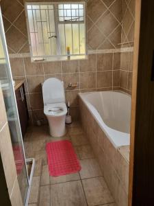 a bathroom with a white tub and a toilet at 540 BIRSTON in Pretoria