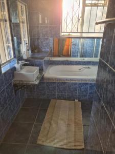 a bathroom with a tub and a sink at 540 BIRSTON in Pretoria