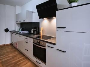 una cucina con armadi bianchi e un grande frigorifero di Appartement SCHILLER II - Erfurt Zentrum a Erfurt