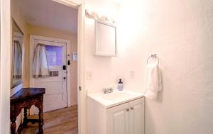 a white bathroom with a sink and a mirror at Charming Basement Studio 2 Blocks from the UofA in Tucson
