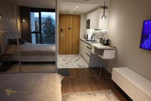 a bedroom with a bed and a kitchen with a sink at UNIA ART Apartament 61 - BASEN, SPA in Lublin