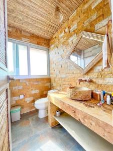 uma casa de banho com um lavatório, um WC e um espelho. em Suite, Eco Hotel Laguna Beach em Tolú