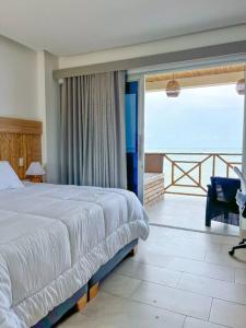 Suite, Eco Hotel Laguna Beach في تولو: غرفة نوم بسرير كبير وبلكونة