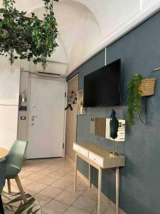 een woonkamer met een tafel en een tv aan de muur bij Blue Marin Apartment in Sanremo