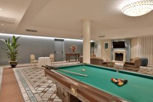 a billiard room with a pool table and a fireplace at Hotel Hermitage in Galatina
