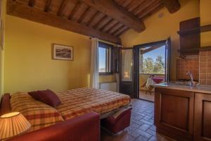 a bedroom with a bed and a kitchen with a window at Agriturismo Buratta in Fonteblanda