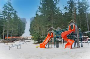um parque infantil com escorrega na areia em Villa Anemar em Blidinje