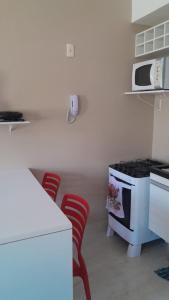 een keuken met rode stoelen en een witte kookplaat bij Lindo Flat em Ponta Negra - Natal in Natal