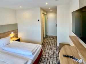 um quarto de hotel com uma cama e uma televisão de ecrã plano em Gasthof Krancher em Rüdesheim am Rhein
