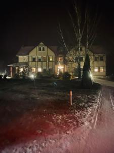 Una casa de noche con las luces encendidas en Hotel Kos en Kosobudz