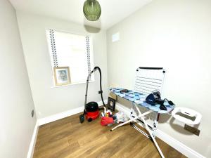a room with a table and a vacuum at Beautiful House in London - Abbey Wood in Abbey Wood