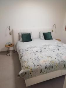 a bedroom with a large white bed with green pillows at Sailors' Park Villa Zephir in Nieuwpoort