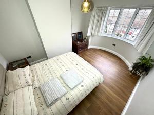 a bedroom with a bed and a large window at Beautiful House in London - Abbey Wood in Abbey Wood