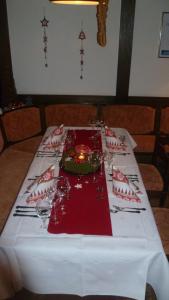 una mesa con un mantel blanco con una vela en Landhaus im Grund en Lennestadt
