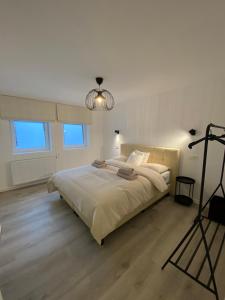 een slaapkamer met een groot bed en een kroonluchter bij Les amies in Blankenberge