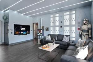 a living room with a couch and a table at Galactic Dream: Arcade, Theater, Minigolf, & more! in Garden Grove