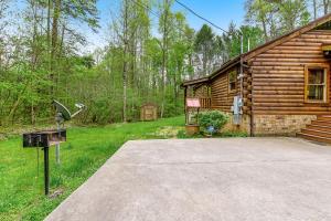 a log cabin with a driveway next to a house at Smoky Bear Cinema in Sevierville