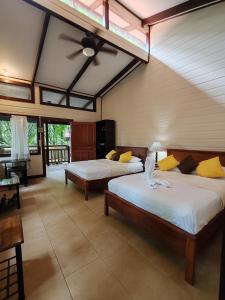 1 dormitorio con 2 camas y ventilador de techo en Evergreen Lodge, en Tortuguero