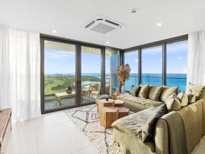 a living room with a couch and large windows at Fourteen at Mullet Bay in Cupecoy