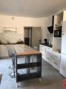 a kitchen with a table and a counter in it at Family cottage 4 chambres in Bourbourg