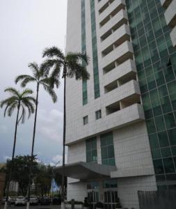 a tall building with palm trees in front of it at Flat particular no Hotel Mercure in Brasília