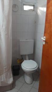 a bathroom with a white toilet and a window at Cabaña Brisas del Lago in Tolhuin