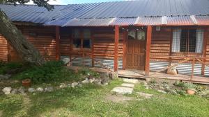 a log cabin with a porch and a door at Cabaña Brisas del Lago in Tolhuin