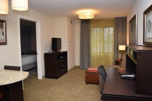 a living room with a room with a couch and a television at Staybridge Suites Syracuse Liverpool, an IHG Hotel in Liverpool