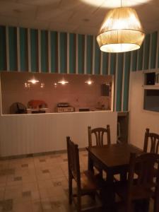 comedor con mesa y sillas y cocina en Hosteria Rukalaf en Mina Clavero