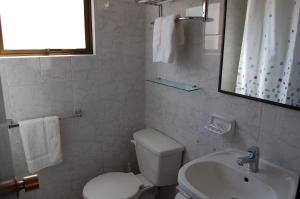 y baño con aseo, lavabo y espejo. en De La Costa Cabañas, en La Serena
