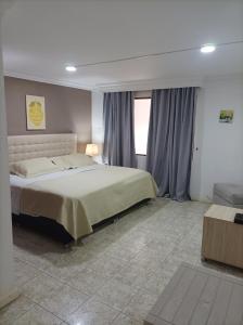 Un dormitorio con una cama grande y una ventana en Conforta Rentals & Spa, en Popayán