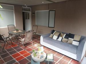 Conforta Rentals & Spa في بوبايان: غرفة معيشة مع أريكة وطاولة